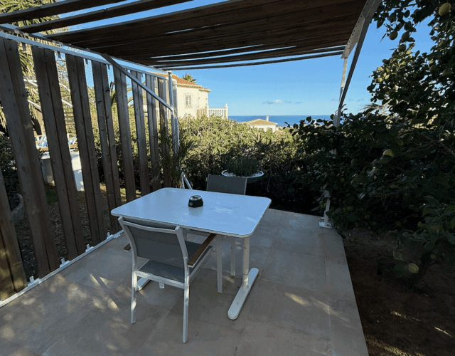 Small outdoor patio with sea views on other side of home.